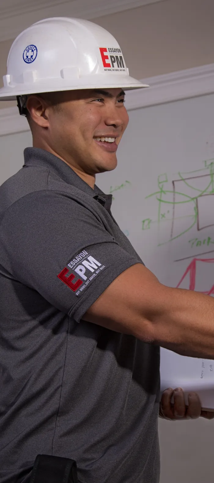 a man wearing a hard hat and holding a whiteboard