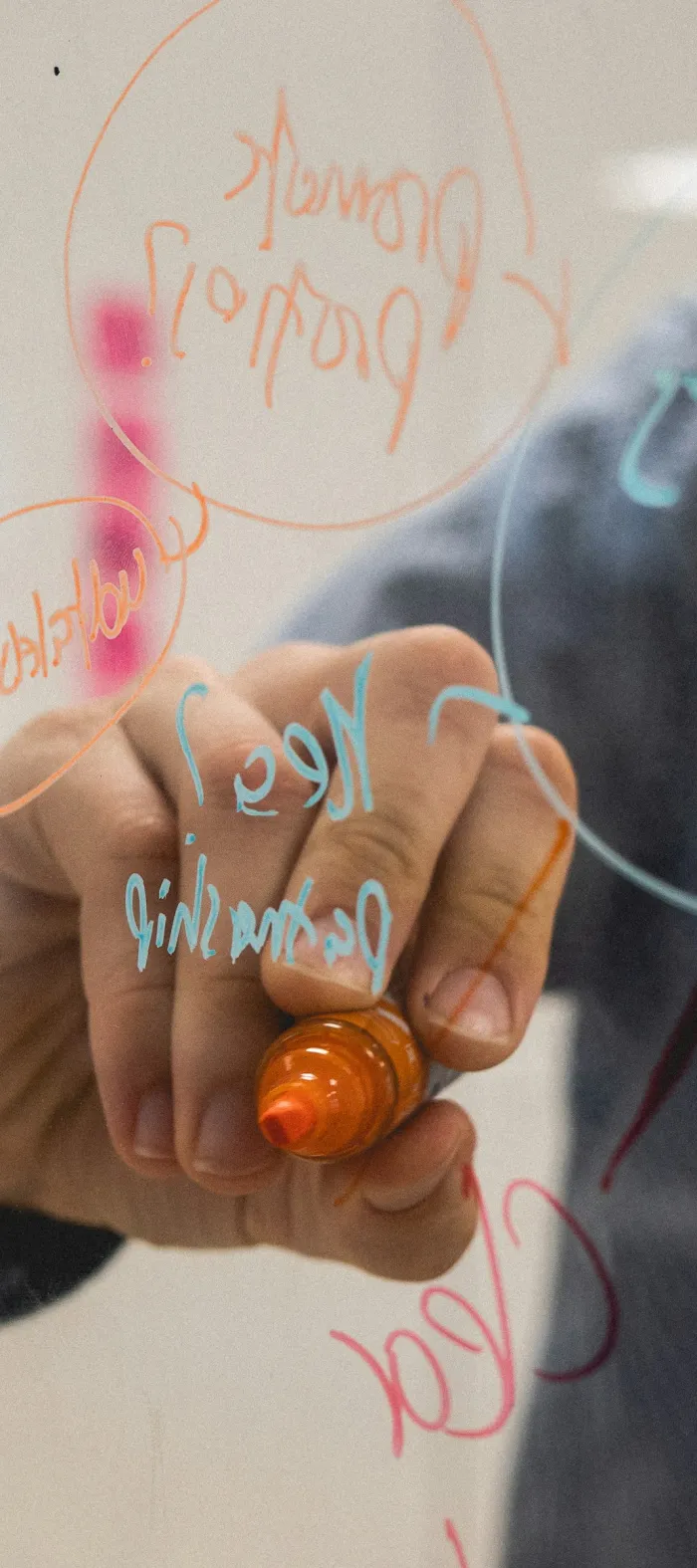 a person writing on a whiteboard