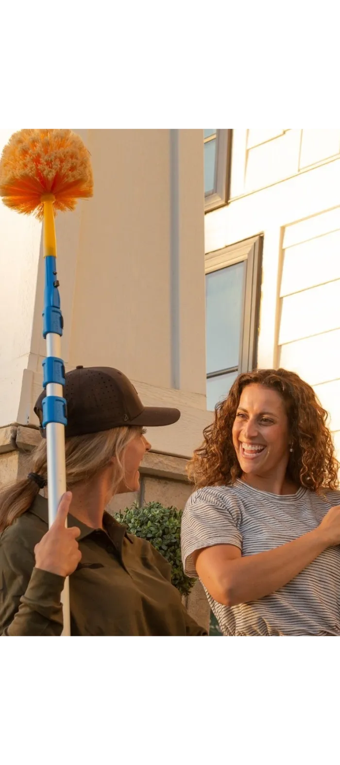 a Ridd technician holding a cob web duster talking to customer