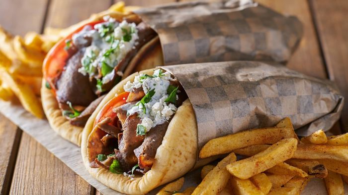 a plate of hot dogs sitting on top of a wooden table