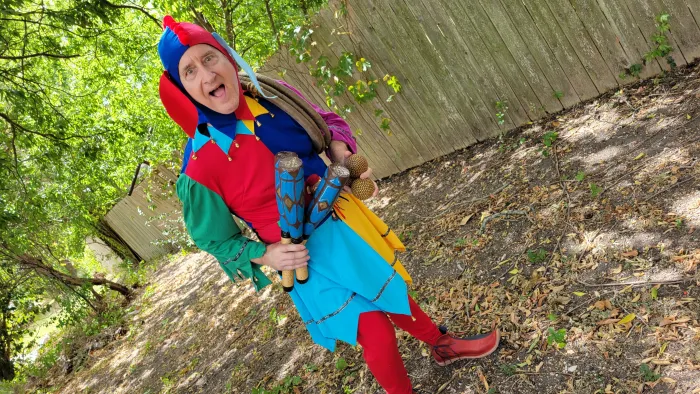 a child in a red hat and blue jacket standing on a log