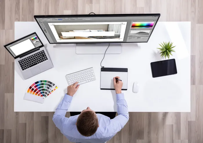 A male graphic designer using computer software to lay out artwork