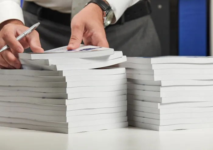 A man inspecting two stacks of Perfect Bound books