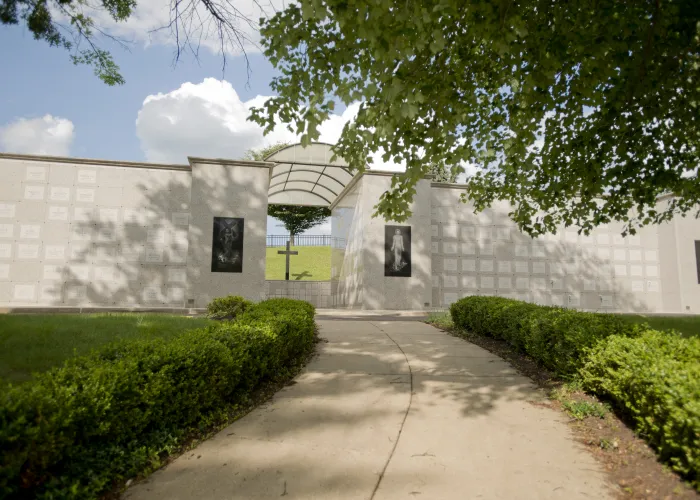 a catholic mausoleum with bushes in front of a building