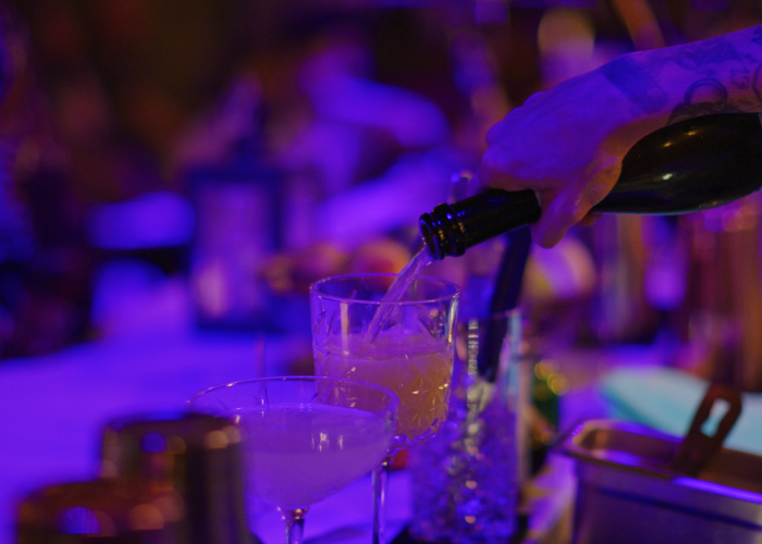 a person pouring a drink into a glass