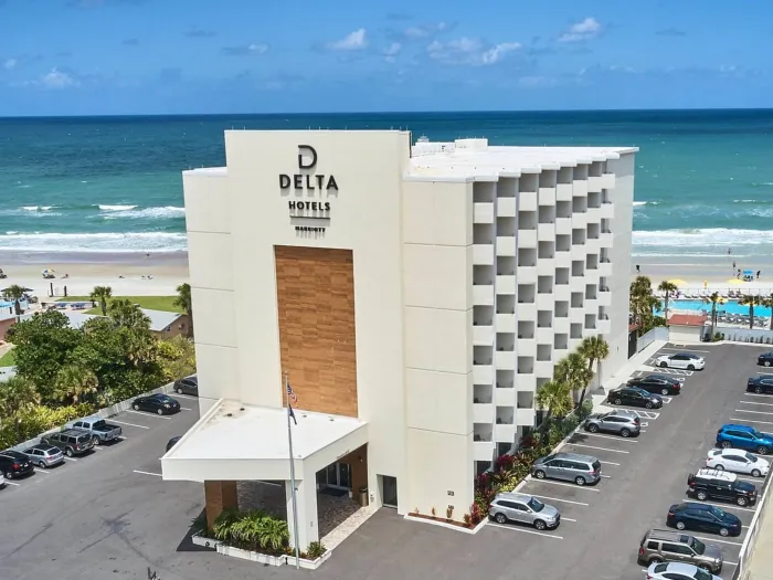 a building with cars parked in front of it by the ocean