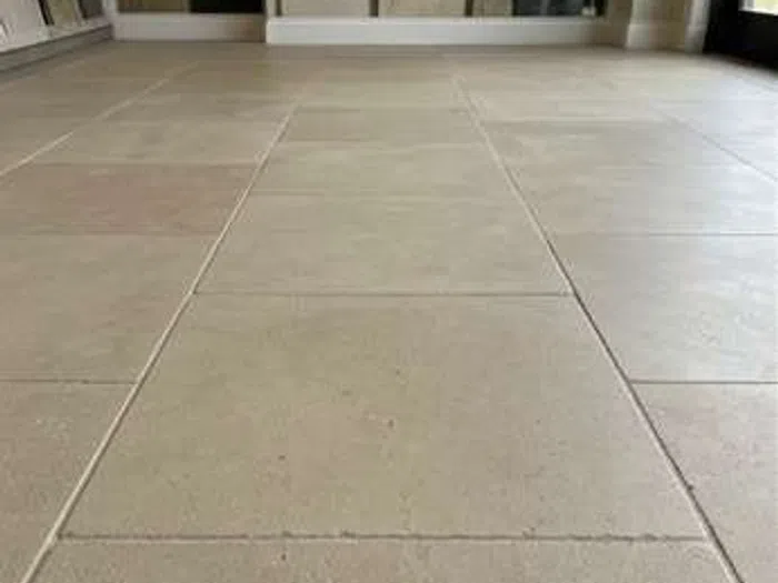 Clean and polished limestone floor tiles in a spacious indoor area after restoration.