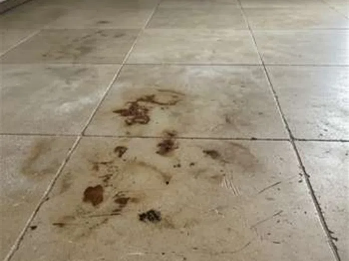 Dirty limestone tiles with visible dark stains and scratches before cleaning treatment.