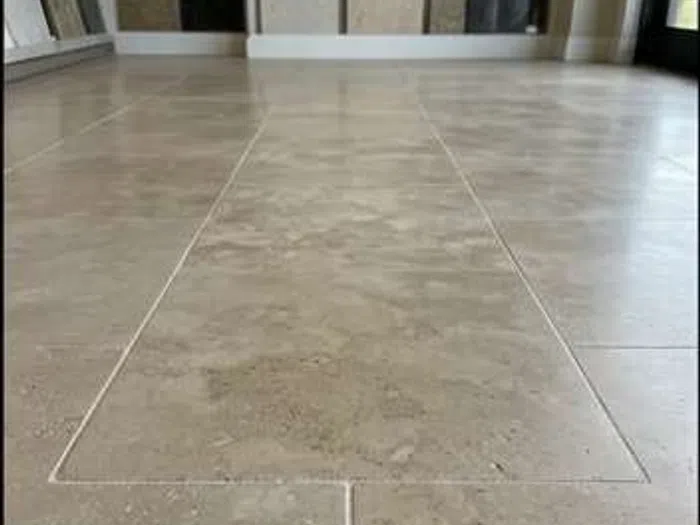 After photo of clean and polished travertine tile flooring with visible grout lines in indoor setting.