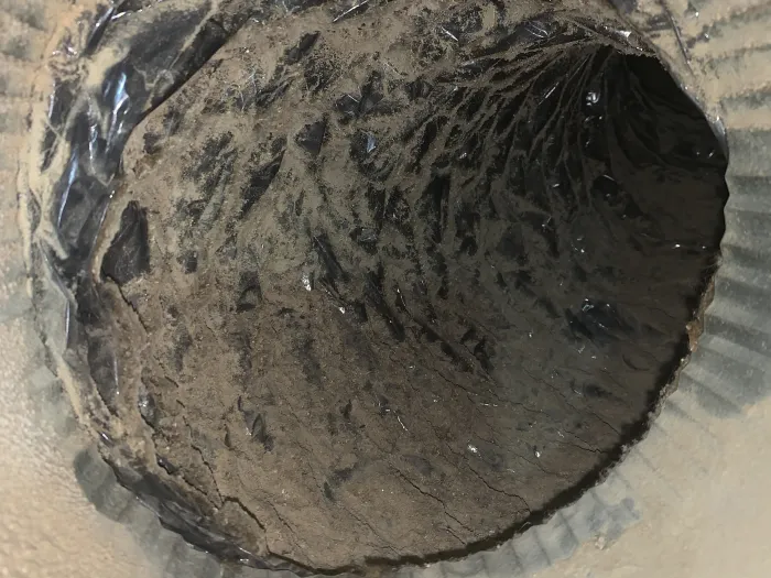 Inside of a dirty HVAC metal vent before it was cleaned