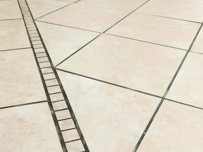 a tiled floor with a a diagonal square detail with dark dirty grout lines