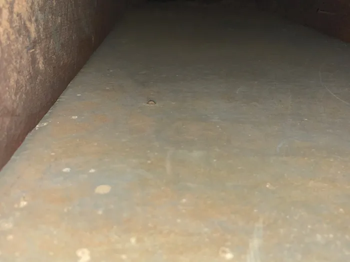 close up interior shot of a wood and metal HVAC system that is now free of the mound of dirt and sludge