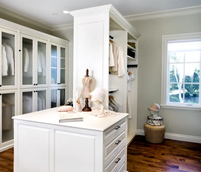 a white kitchen with a white counter top and a statue on top