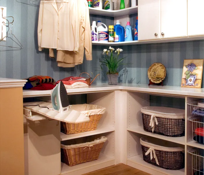 a white shelving unit with a basket and a basket of clothes