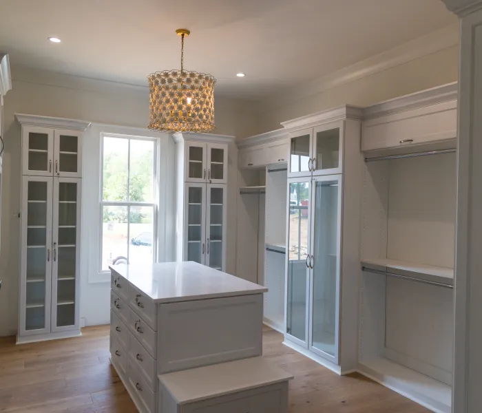 a room with white cabinets and a chandelier