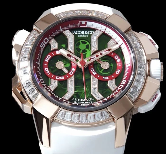 a silver watch with a red face