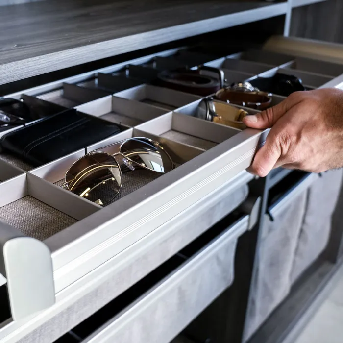 a person opening a custom closet drawer with a sunglasses organizing tray