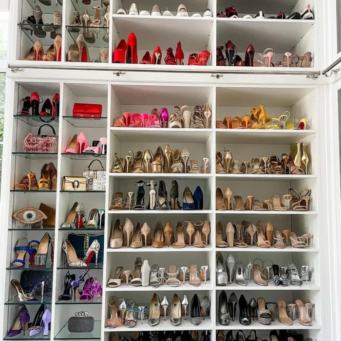 Custom shoe closet or dream closet with high heels on glass shelves and white shelves.