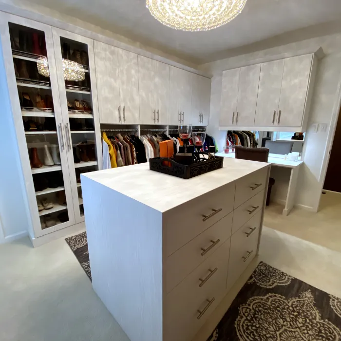 a custom closet with white cabinets