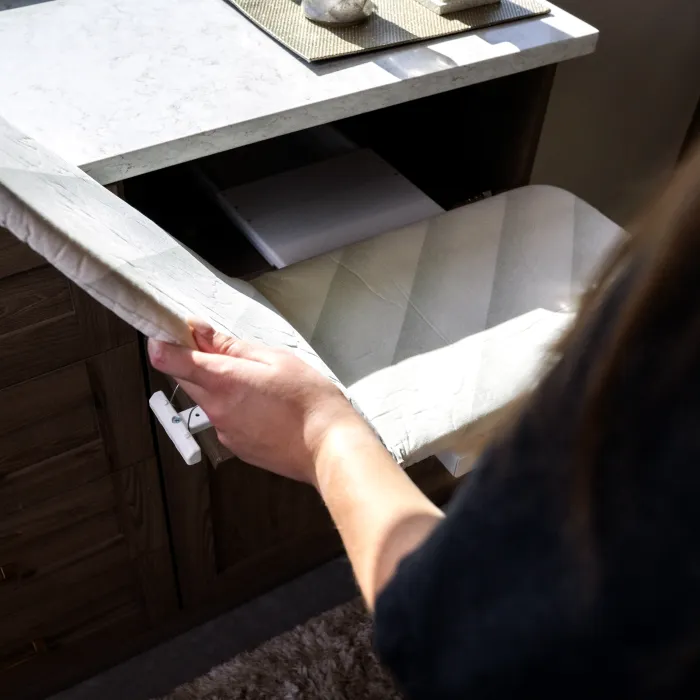 a fold out ironing board in a custom laudry room