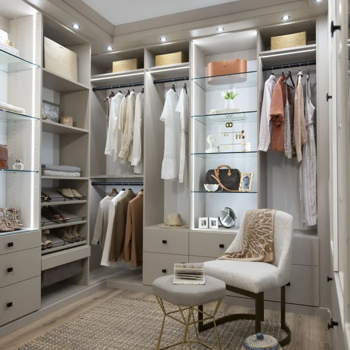 a closet with clothes and a chair