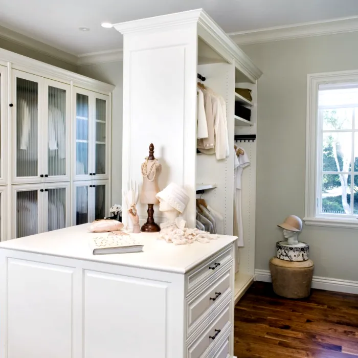 a white kitchen with a white counter top and a statue on top