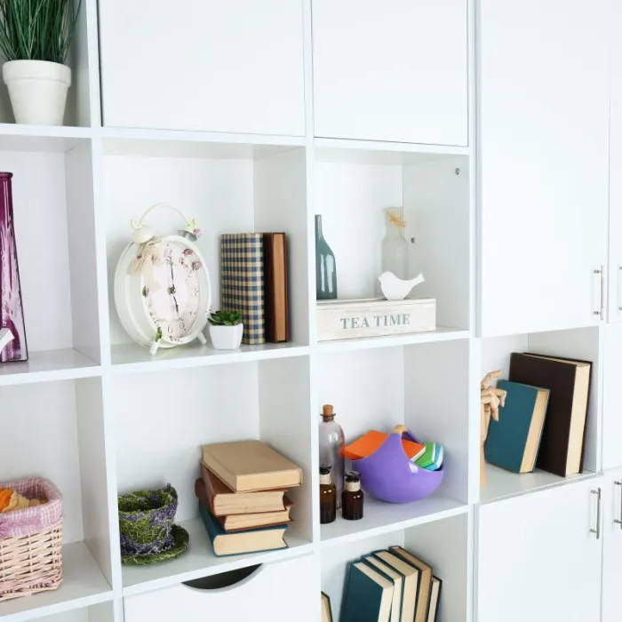 a white cabinet with a clock and other objects