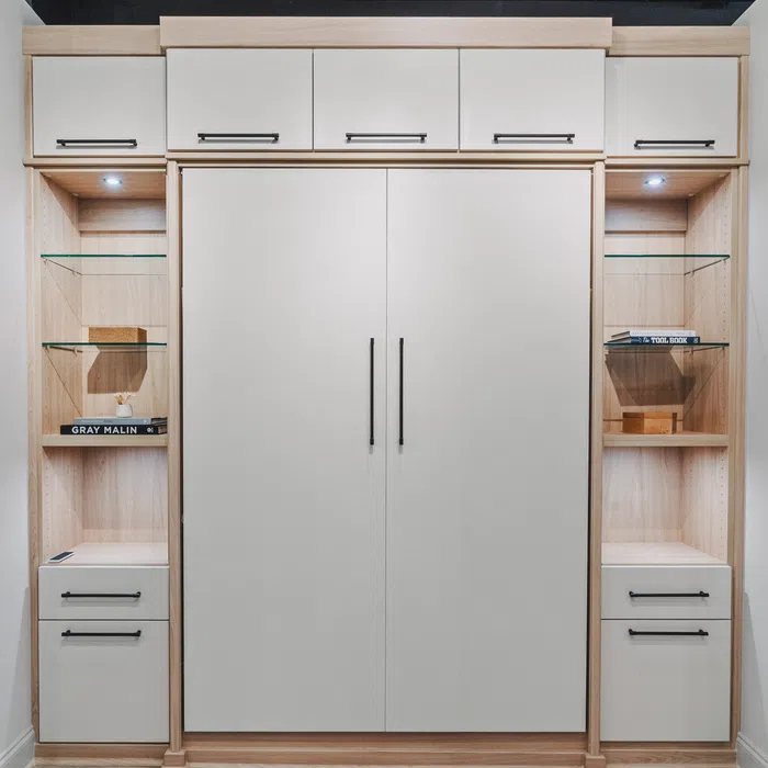 Modern white and wood built-in storage with closed cabinets, open shelves with glass, and spotlighting