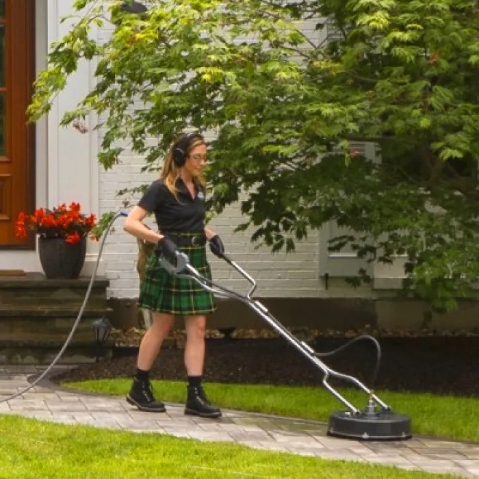 a woman cleaning a sidewalk