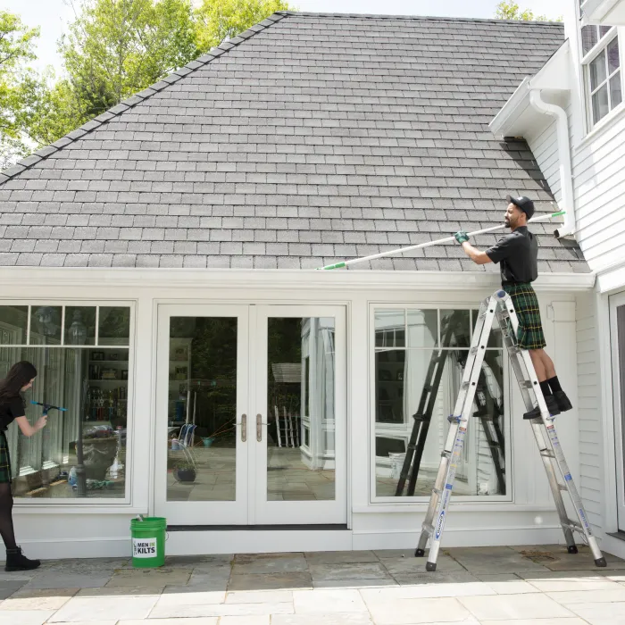 a person on a ladder painting a house