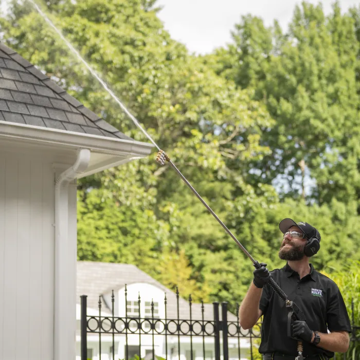 a person pressure washing a house