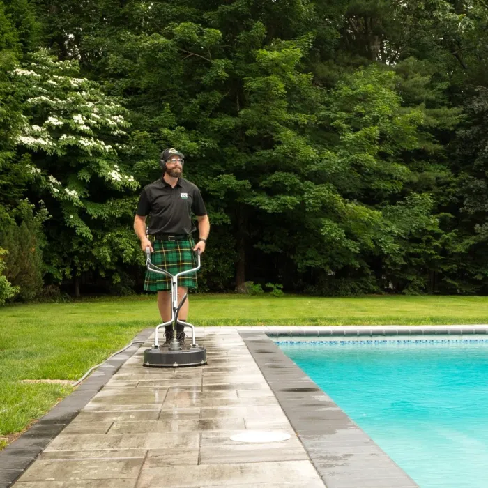 a man standing on a platform near a pool