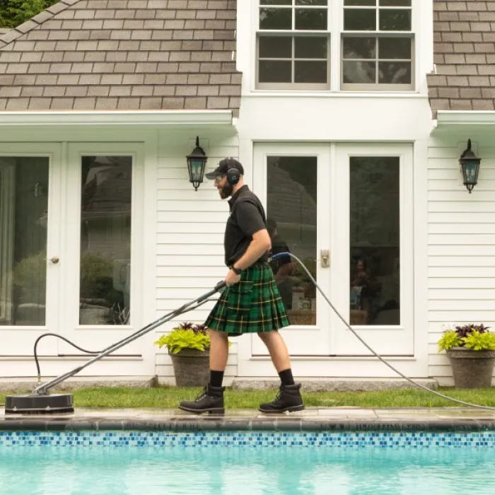 a person in a kilt holding a pool stick