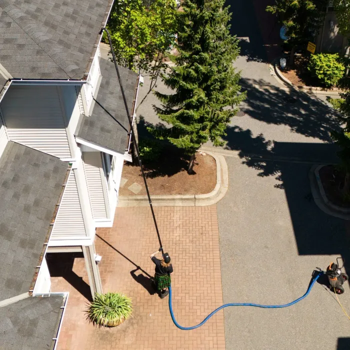 a person cleaning a gutter with a vacuum