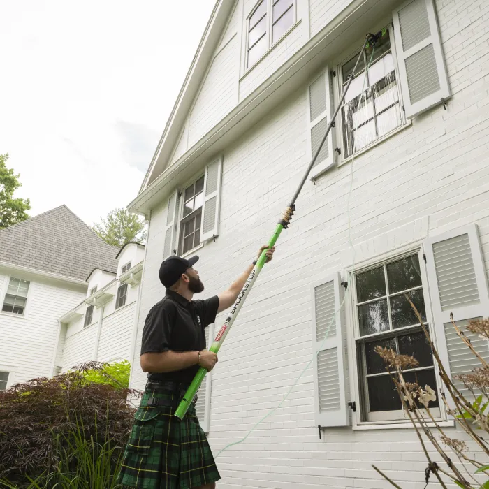 a man holding a broom outside a house