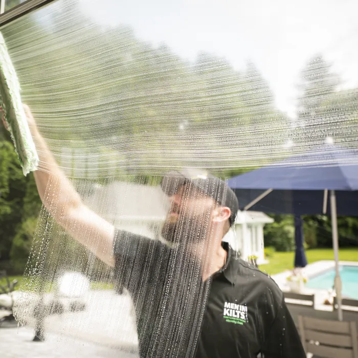 a man spraying water on a pool