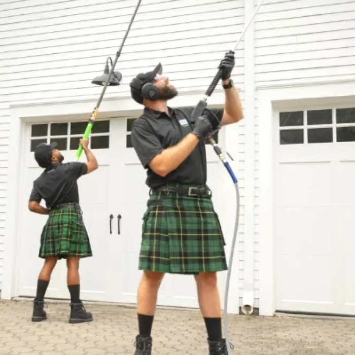 a person wearing a kilt and washing a house