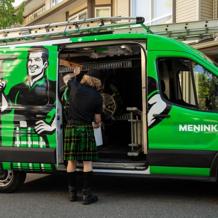 a person standing next to a green van