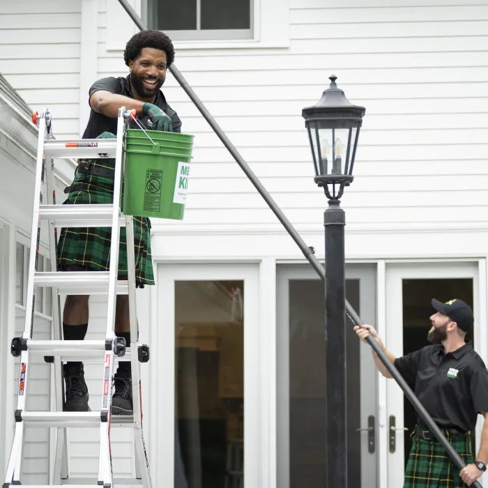 two men in kilts cleaning gutters