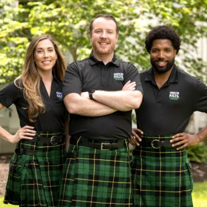 a group of people in kilts posing for a photo