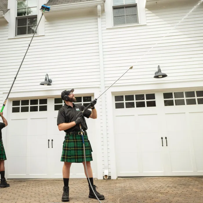 a person in a kilt holding a gun in front of a white building