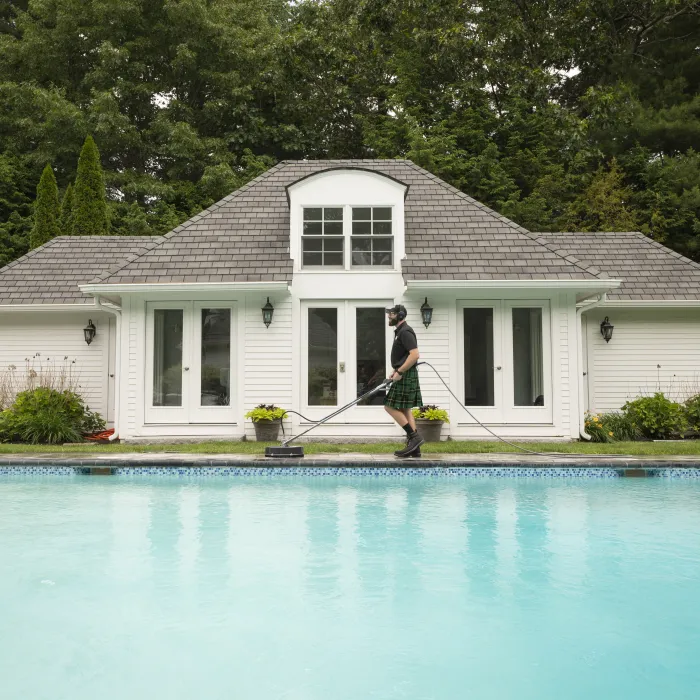 a person holding a surfboard next to a swimming pool