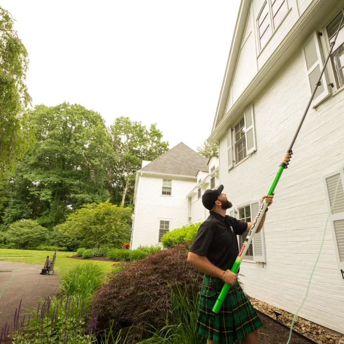 a man holding a broom outside a house