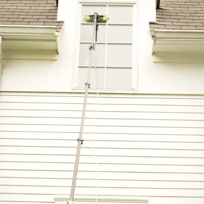 a water-fed pole washing a window