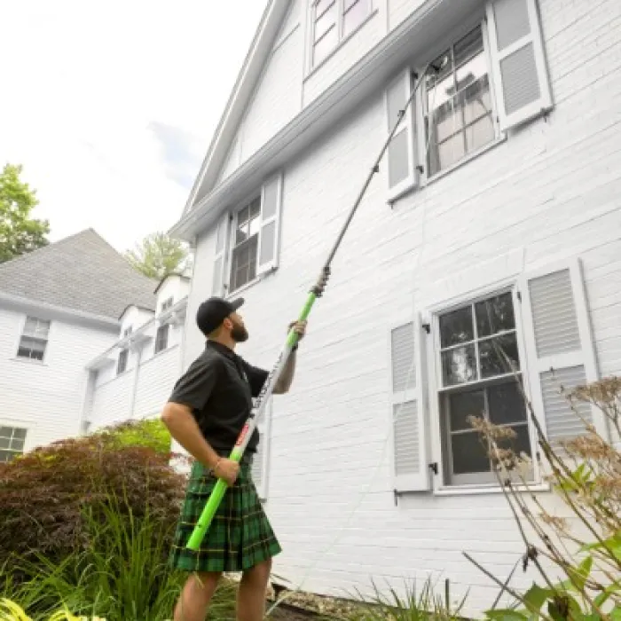 a man holding a broom outside a house