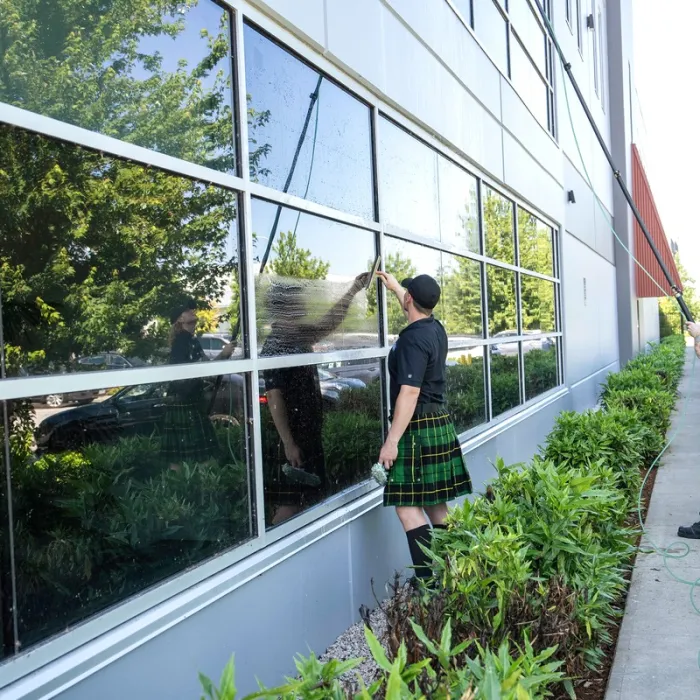 a group of people outside washing windows on a building