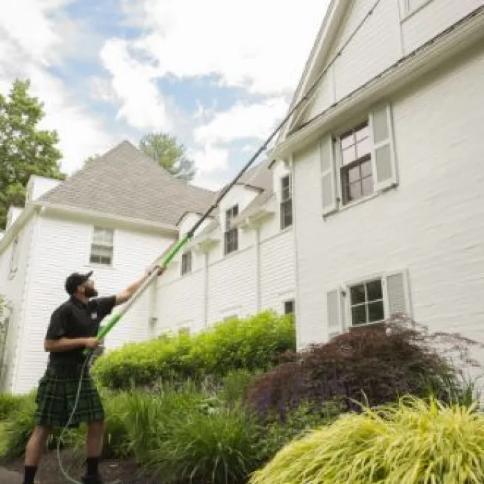 a man cleaning a window outside of a house