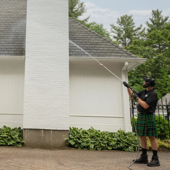 a couple of men holding a bow and arrow in front of a house