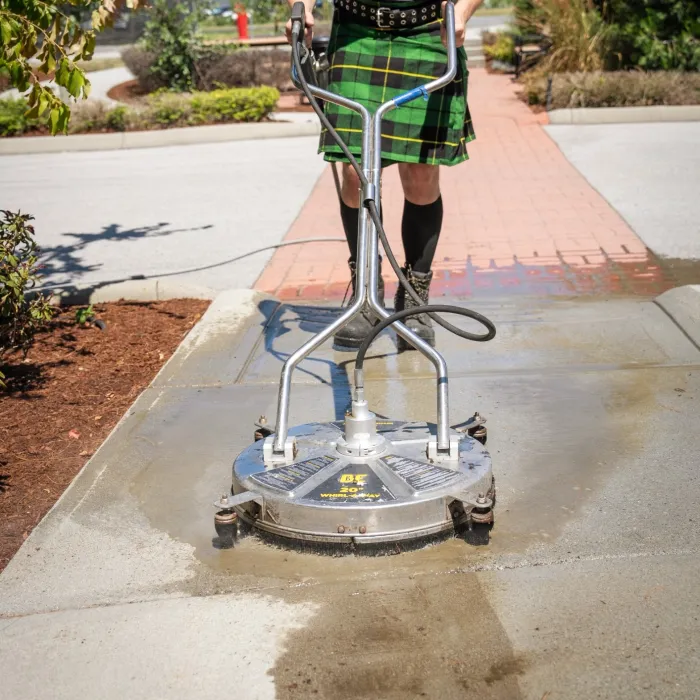 a man wearing a kilt surface washing a sidewalk