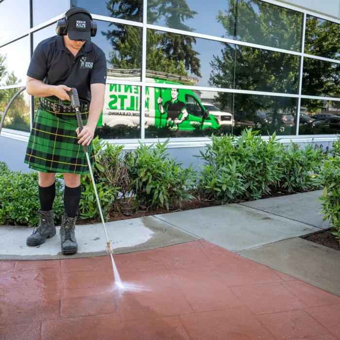 a person in a kilt using a pressure washer